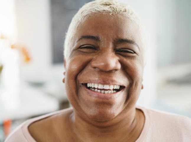 An african american woman is smiling at the camera.