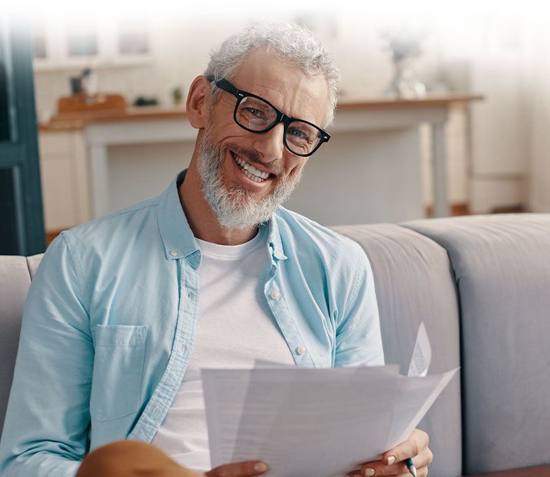 A man with **attachment** issues and a beard sitting on a couch, participating in the **trauma mastery program**.