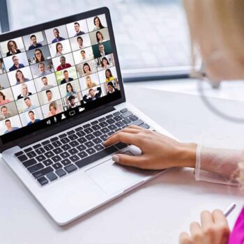 Trauma Solutions: Person using a laptop to join a video conference call with multiple participants visible in a grid on the screen.