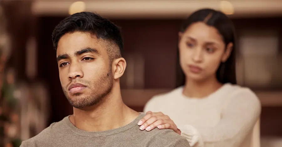 Trauma Solutions: A woman places her hand on the shoulder of a man who is looking away with a somber expression.