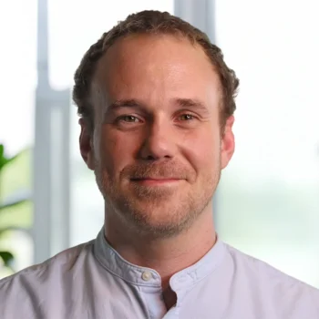 Trauma Solutions: A man with short brown hair and a light beard smiling toward the camera.
