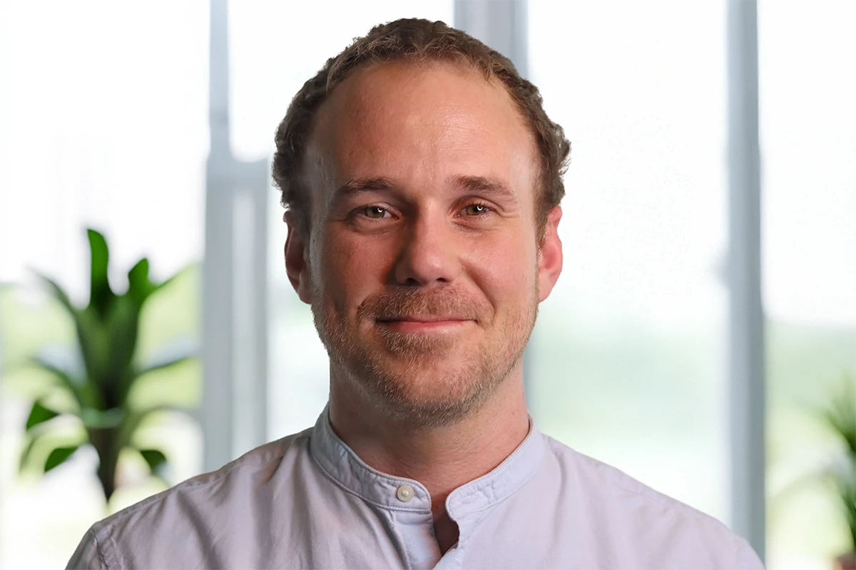 Trauma Solutions: A man with short brown hair and a light beard smiling toward the camera.