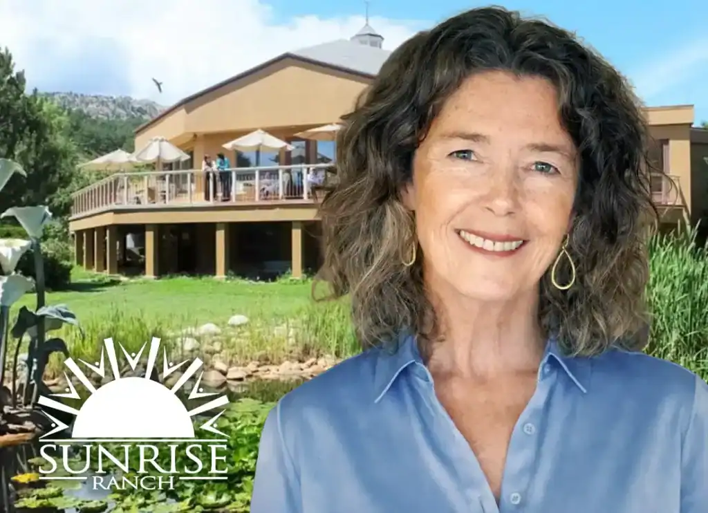 Trauma Solutions: A woman with curly gray hair smiles in front of a building with a balcony and umbrellas. The "Sunrise Ranch" logo is in the bottom left corner.