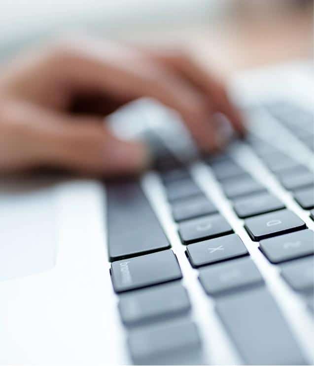 A person's hand typing on a laptop keyboard while participating in the DARe Certificate Program.