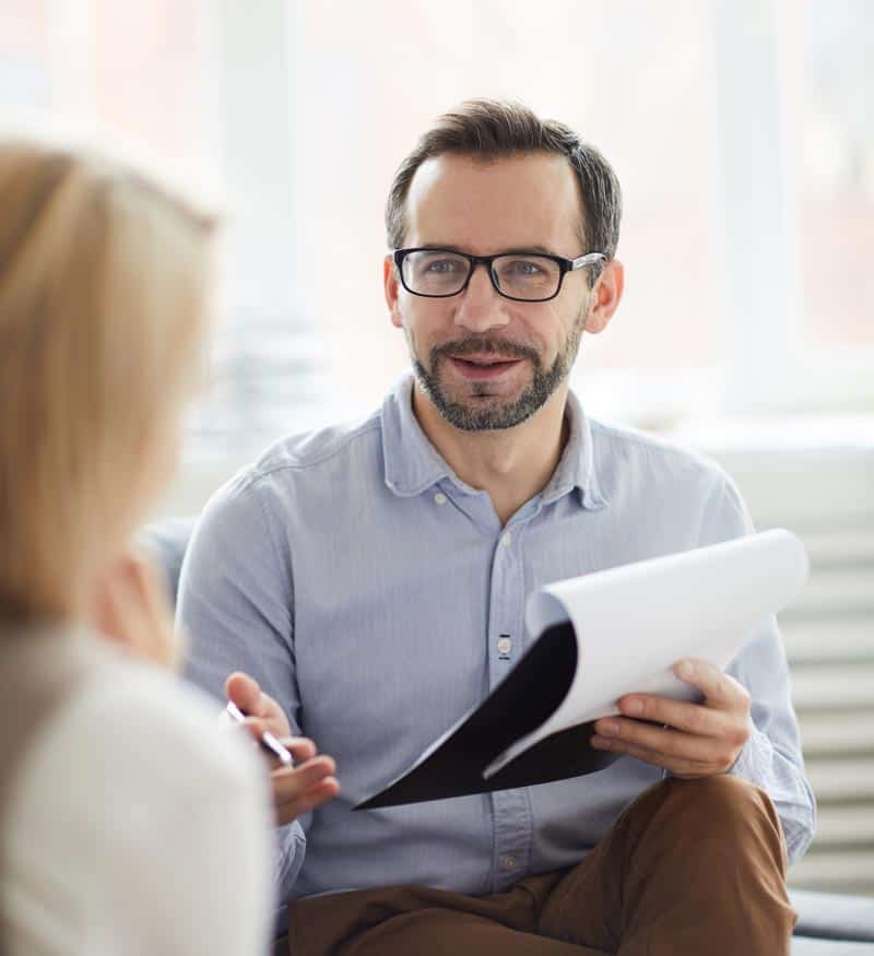 A man is engaging in a DARe conversation with a woman in an office.