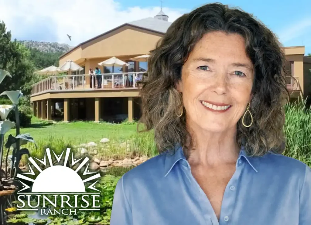 Trauma Solutions: A woman with wavy hair and a blue shirt smiles in front of a building with balconies and umbrellas, with a “Sunrise Ranch” logo in the corner.