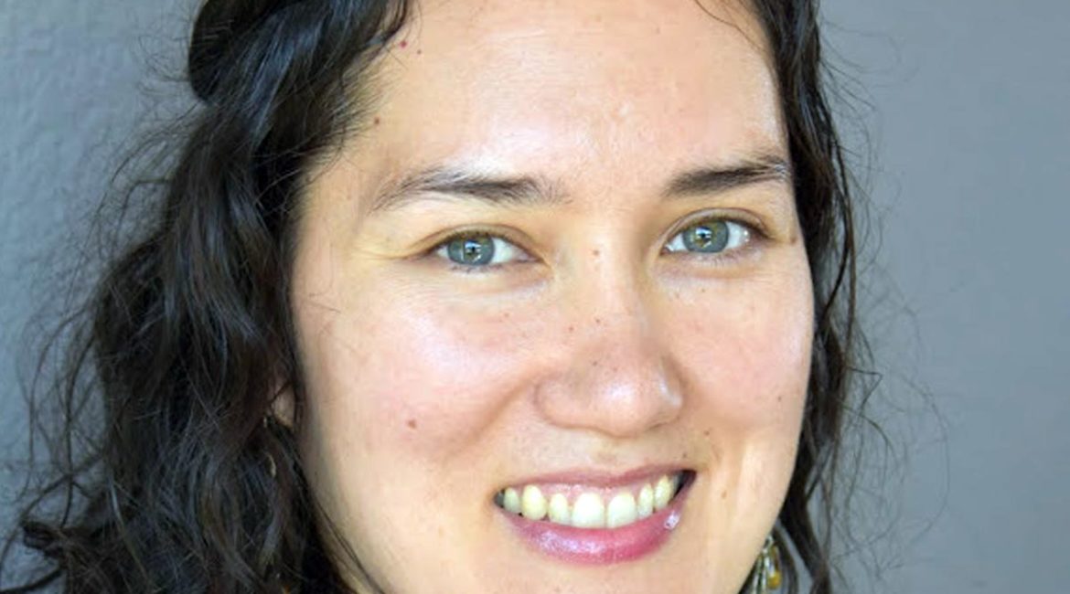 Erin Hernandez, a smiling woman wearing a blue shirt.