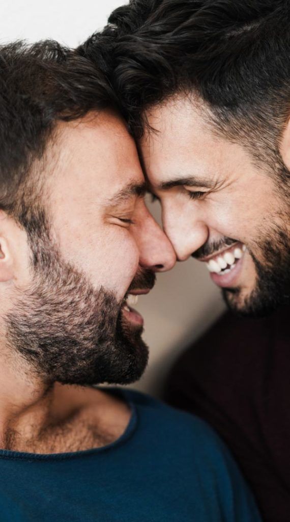 Two men with beards looking at each other.