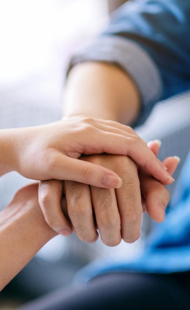 A couple demonstrating the DARe Approach by holding hands.