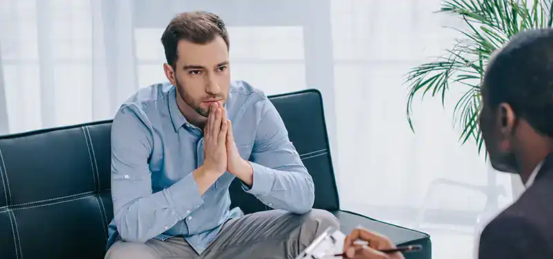 A man sits attentive and focused on his therapist. When the nervous system is given time to regulate, rather than collapse into shame, insight and change become possible.