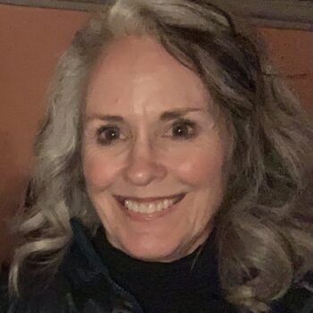 A woman with gray hair smiling for the camera.