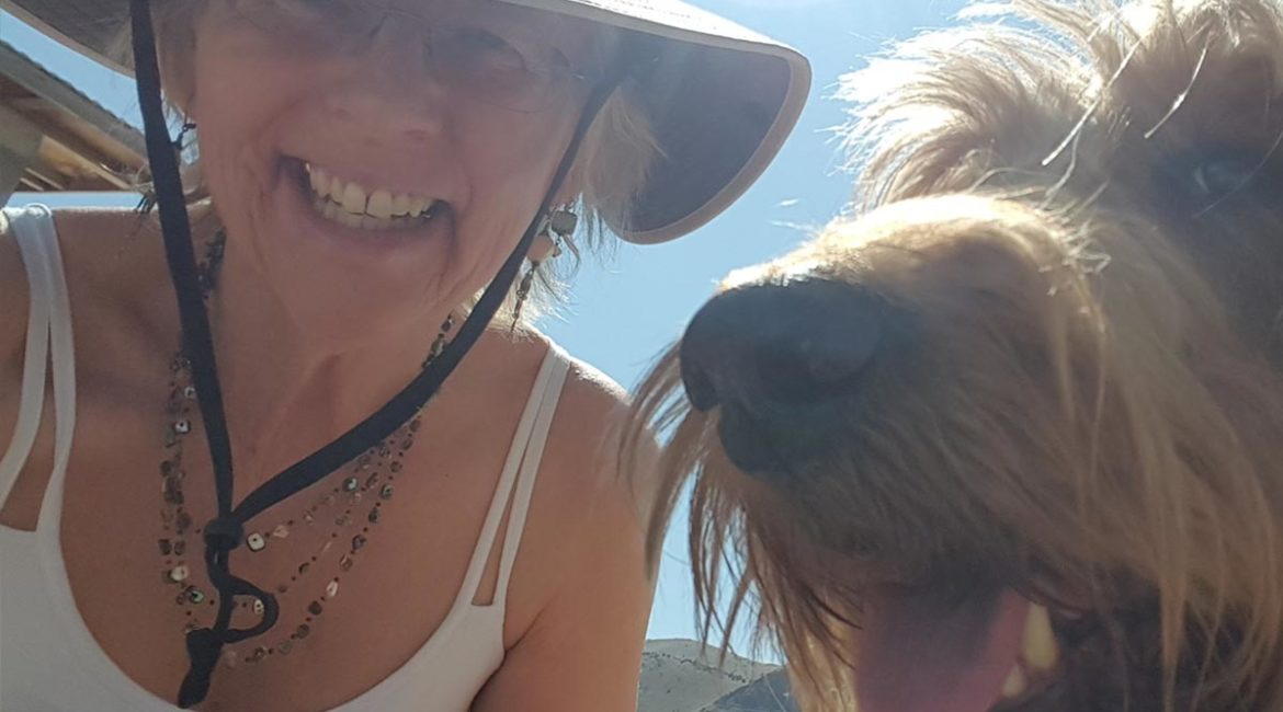 A woman with a hat and a dog.