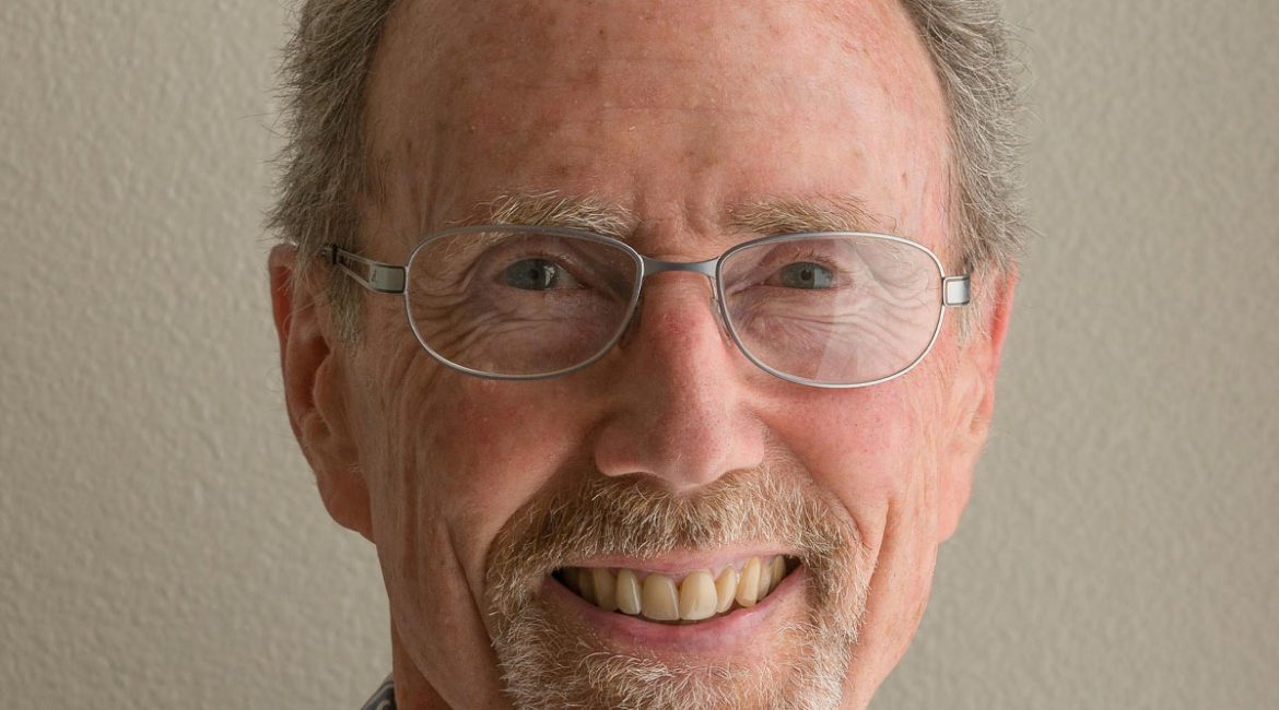 A man wearing glasses and a hawaiian shirt.