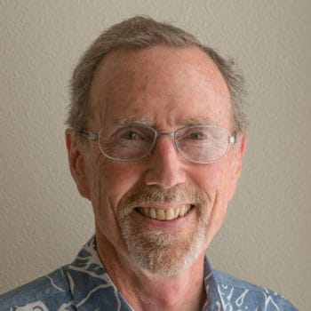 A man wearing glasses and a hawaiian shirt.