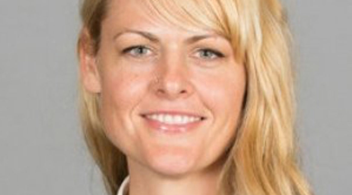 A woman with long blonde hair smiling for the camera.