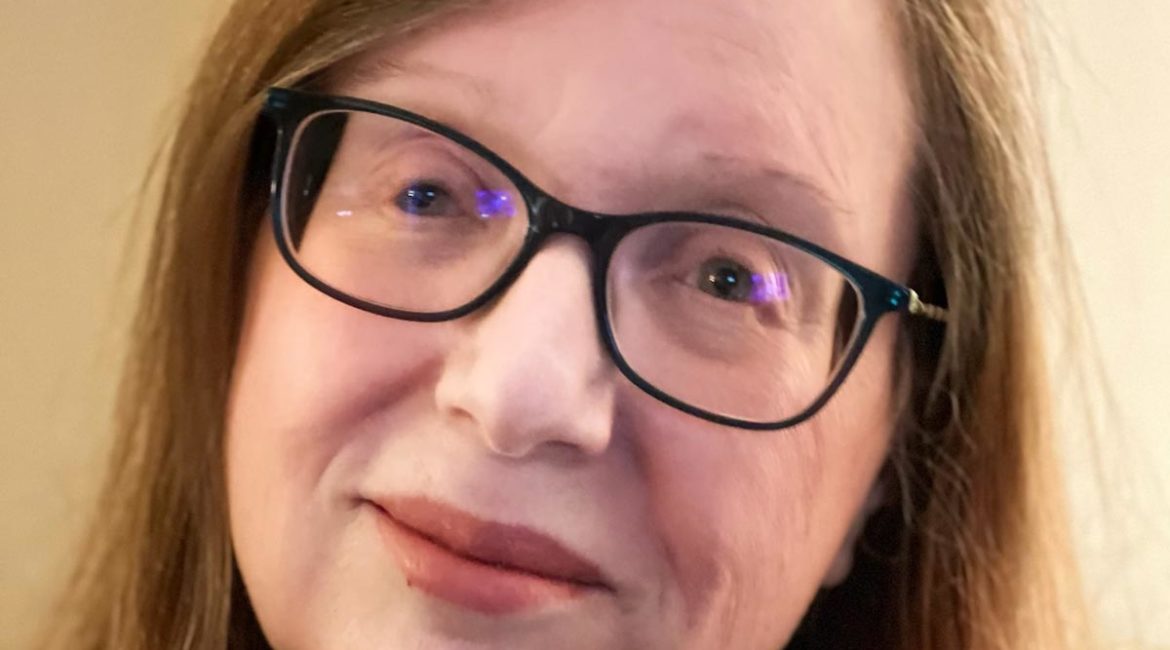 A woman wearing glasses and a sweater.