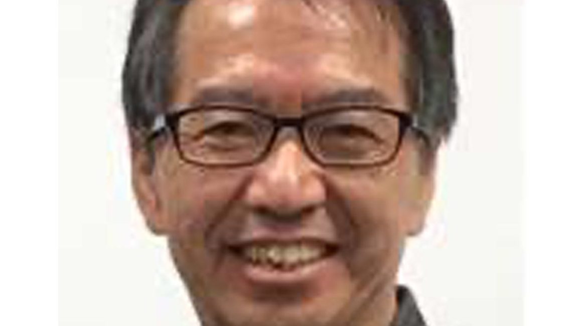 An asian man in glasses smiling for the camera.