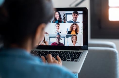 A woman is using a laptop with a group of people on it.