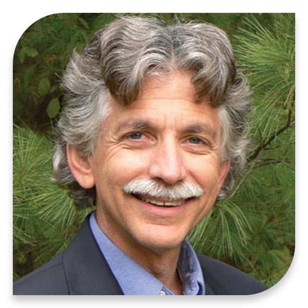 A man with a mustache in front of a tree at home.