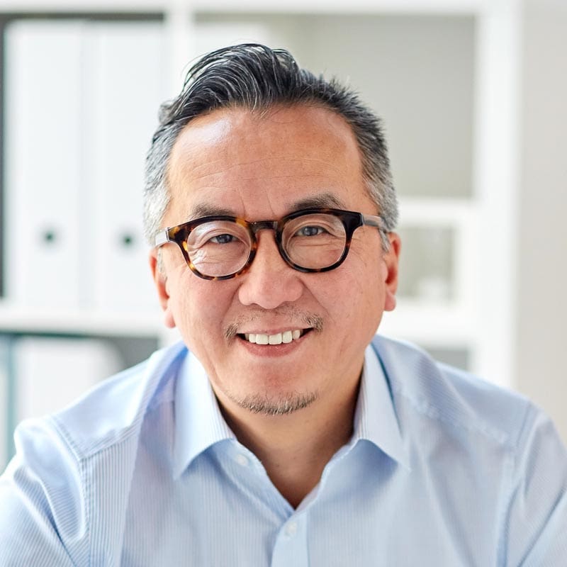 A man in glasses is smiling in an office at a therapy session.