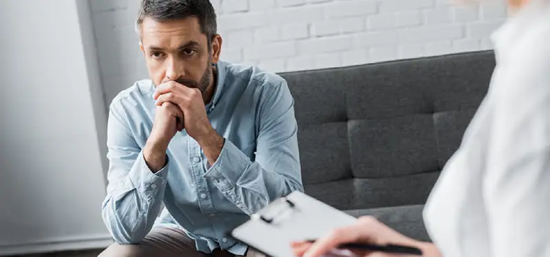 Trauma Solutions: A client in therapy session looking anxious and activated. Tracking a client’s physiological state is just one aspect of clinical work, and bringing in other models can help deepen trauma healing.