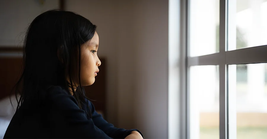Trauma Solutions: A young girl gazes out a window.